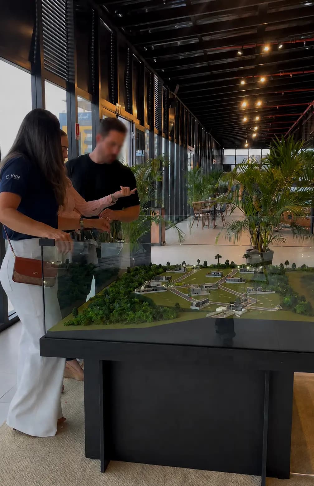 Consultora da VKR apresentando a maquete de um empreendimento a um cliente